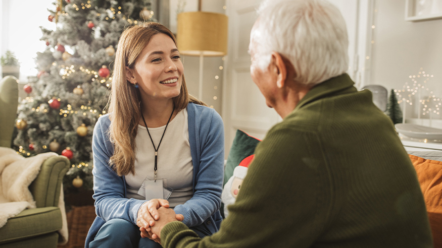 Daughter talking with elderly father at Christmas